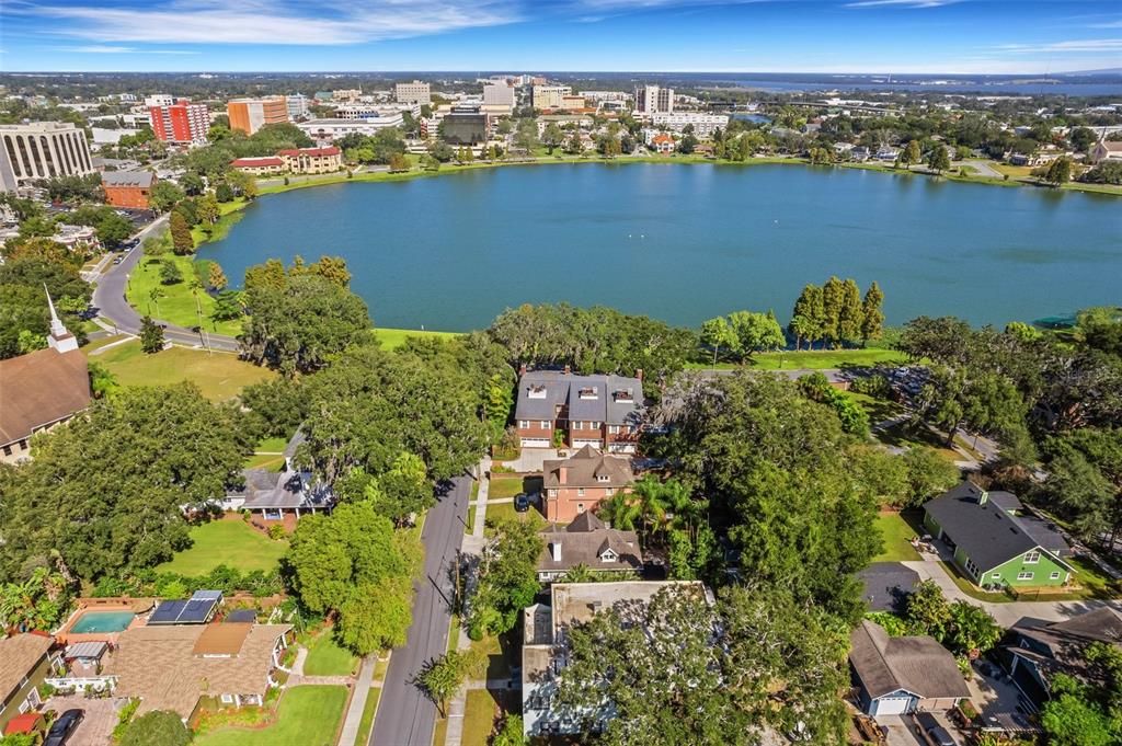 An aerial view shows a residential neighborhood situated along the shore of a large lake — 155 LAKE MORTON DRIVE UNIT 1, LAKELAND, FL
