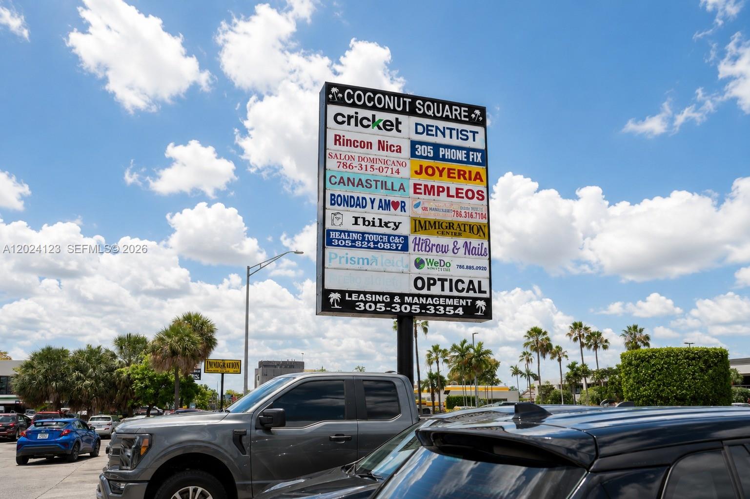 A large commercial plaza sign stands in a parking lot under a blue sky — 4355 W 16th Ave, Hialeah FL 33012, HIALEAH, FL