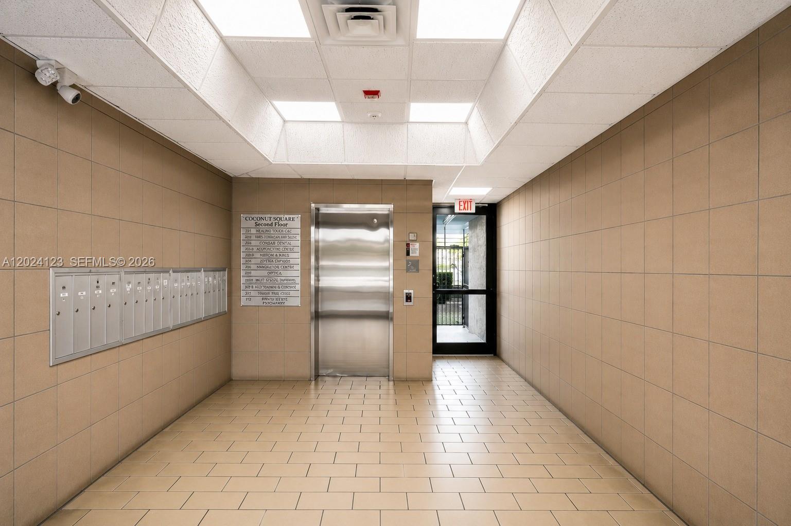 A hallway features tiled walls and floors, a central elevator, mailboxes, and an exit door — 4355 W 16th Ave, Hialeah FL 33012, HIALEAH, FL