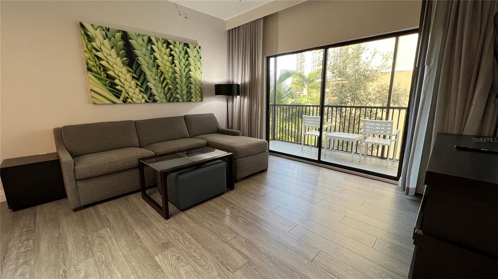 A living room features a gray sectional sofa, a glass coffee table, and a balcony — 14501 GROVE RESORT AVENUE UNIT 2233, WINTER GARDEN, FL