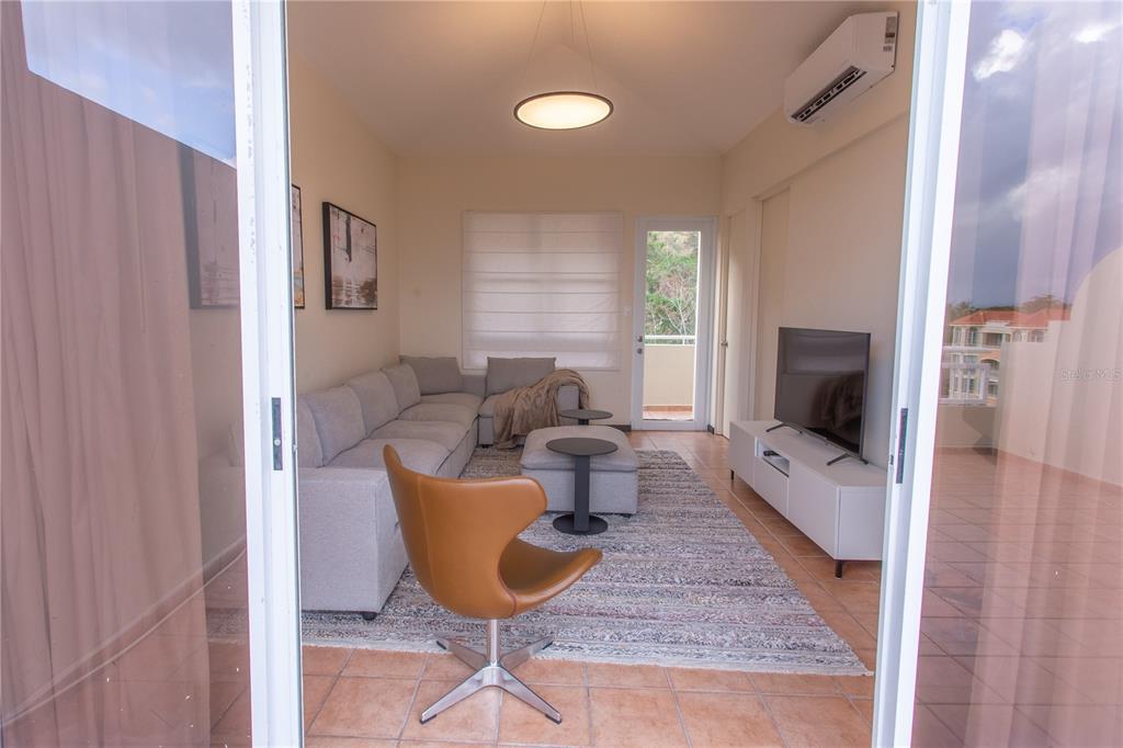 A living room features a gray sectional sofa, a brown accent chair, and a television — 115 CARRETERA 115, KM. 5.8 UNIT 603-A, ANASCO, PR