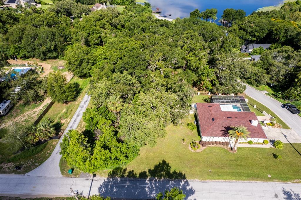 An aerial view shows a house with a pool and a large wooded lot — COUNTRY CLUB ROAD, EUSTIS, FL