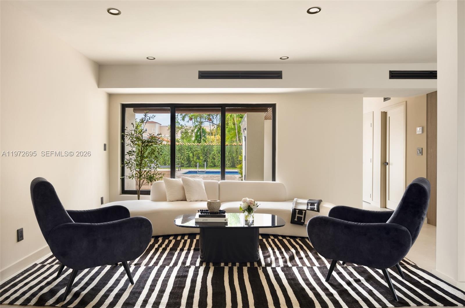 A modern living room features light tile floors, a striped rug, and dark accent furniture — 2805 SW 4th Ave, Miami FL 33129, MIAMI, FL