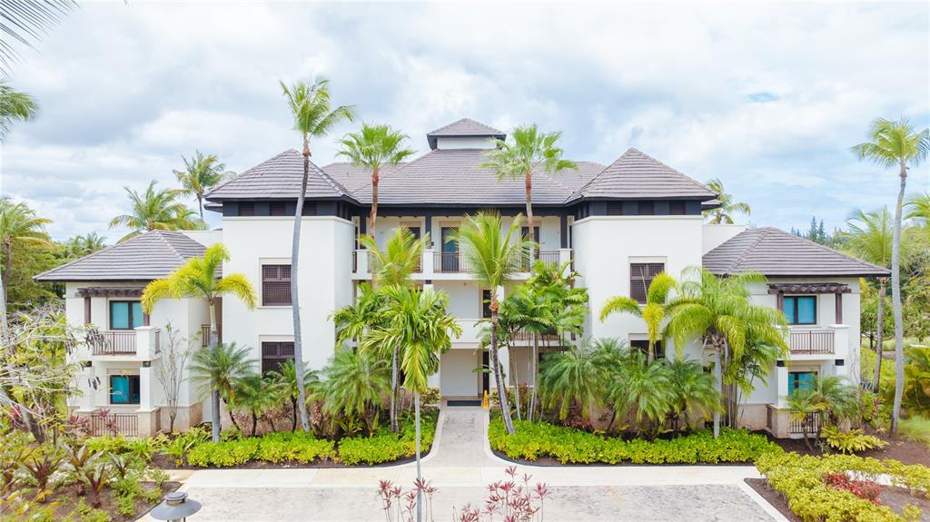 A three-story residential building with a tiled roof is surrounded by lush tropical landscaping — Bahia Beach Golf Club LAS VERANDAS CONDOMINIUM UNIT PH 4333, RIO GRANDE, PR