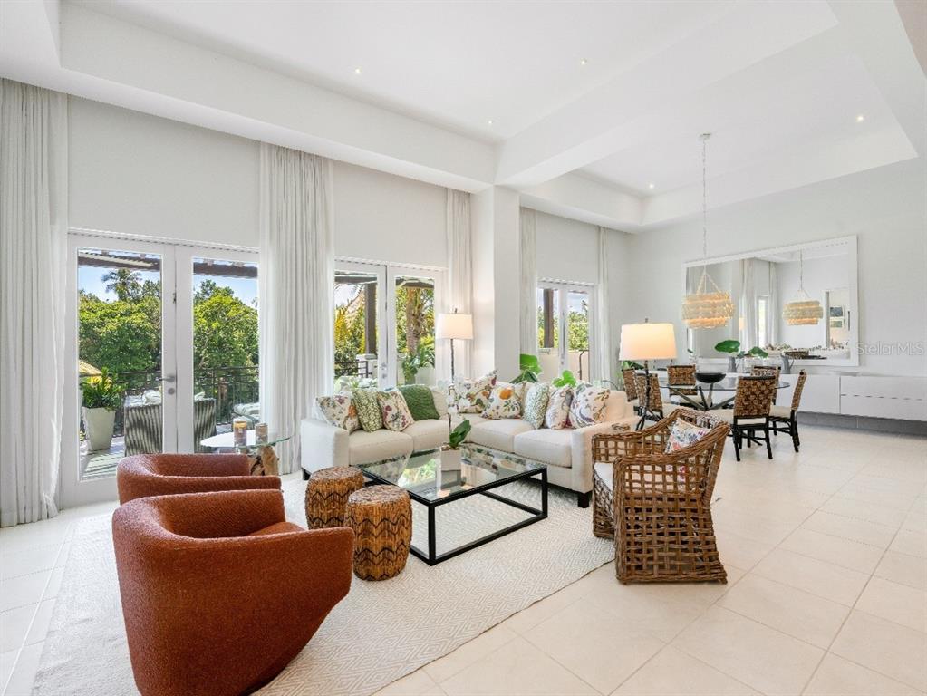A bright, open-concept living and dining area features white tile floors and large glass doors — Bahia Beach Golf Club LAS VERANDAS CONDOMINIUM UNIT PH 4333, RIO GRANDE, PR