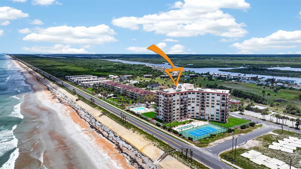An aerial view shows a multi-story beachfront condominium building with a tennis court and pool — 3600 S OCEAN SHORE BOULEVARD UNIT 219, FLAGLER BEACH, FL