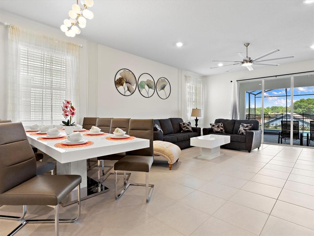A dining area and living room with tile floors, modern furniture, and a ceiling fan — 3835 LANA AVENUE, DAVENPORT, FL