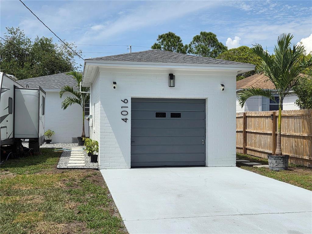 A detached white brick garage with a gray door and a concrete driveway — 4016 9TH AVENUE N, ST PETERSBURG, FL