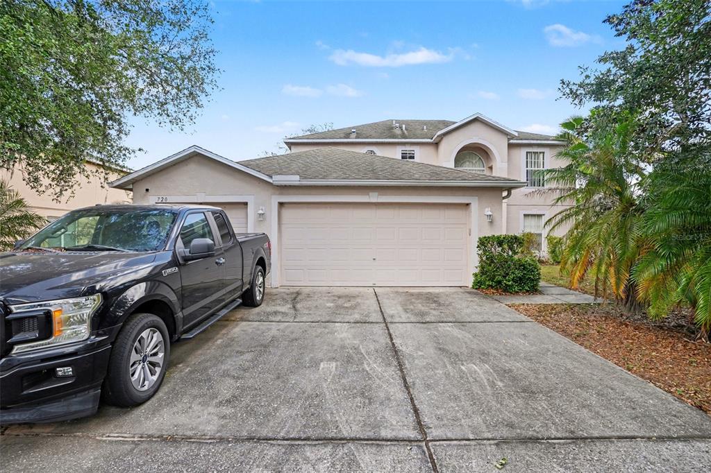 A two-story house with a beige exterior, a two-car garage, and a black pickup truck — 720 VALRICO HILLS LANE, VALRICO, FL
