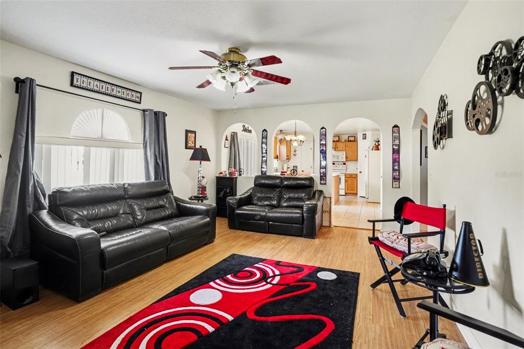 A living room features black leather sofas, a red and black rug, and arched doorways — 720 VALRICO HILLS LANE, VALRICO, FL