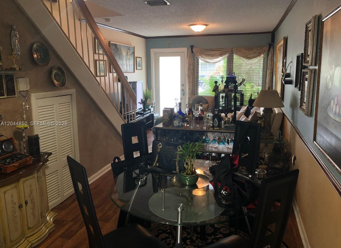A dining area with a glass table and stairs leads into a living room space — 248 Majorca Ave # 248, Coral Gables FL 33134, CORAL GABLES, FL