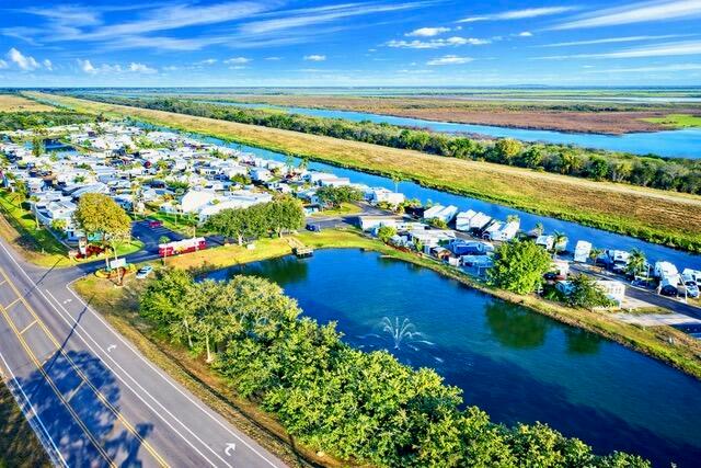 An aerial view shows a mobile home park situated next to a pond and highway — 7950 W Hwy 78 Highway, Okeechobee FL 34974, OKEECHOBEE, FL