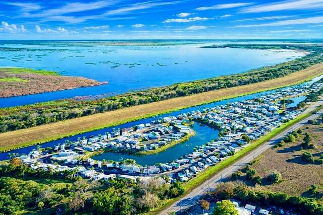 An aerial view shows a large RV park situated along a canal near a lake — 7950 W Hwy 78 Highway, Okeechobee FL 34974, OKEECHOBEE, FL