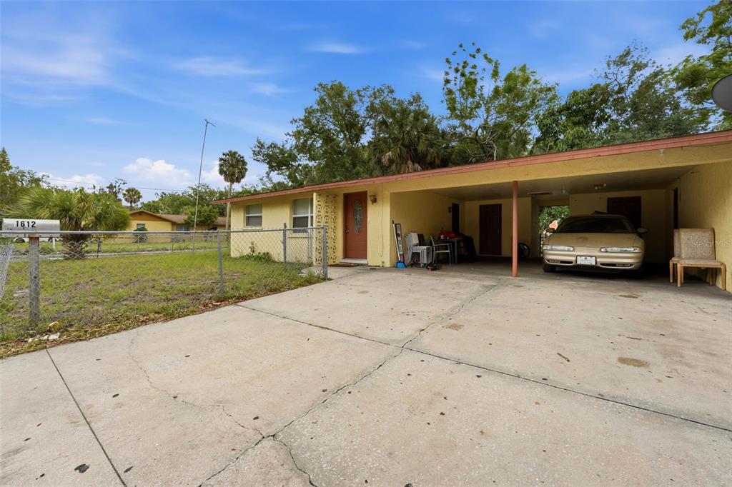 A single-story house with a yellow exterior, a concrete driveway, and an attached carport — 1610 22ND STREET, SARASOTA, FL