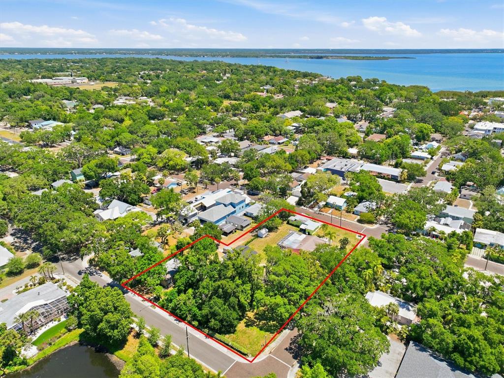 An aerial view shows a residential lot outlined in red within a wooded neighborhood — 515 2ND STREET N, SAFETY HARBOR, FL