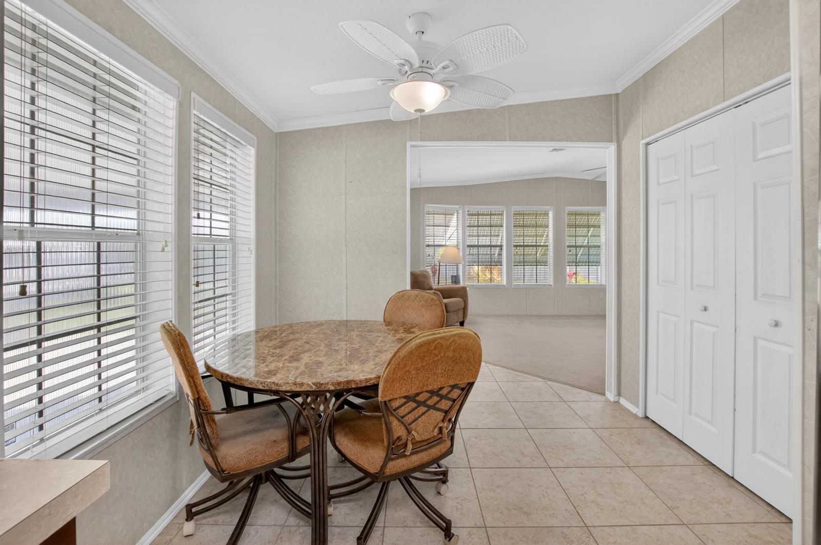 A dining area with a marble-top table, tiled floors, and a ceiling fan — 5006 Curacas Bay, Boynton Beach FL 33436, BOYNTON BEACH, FL