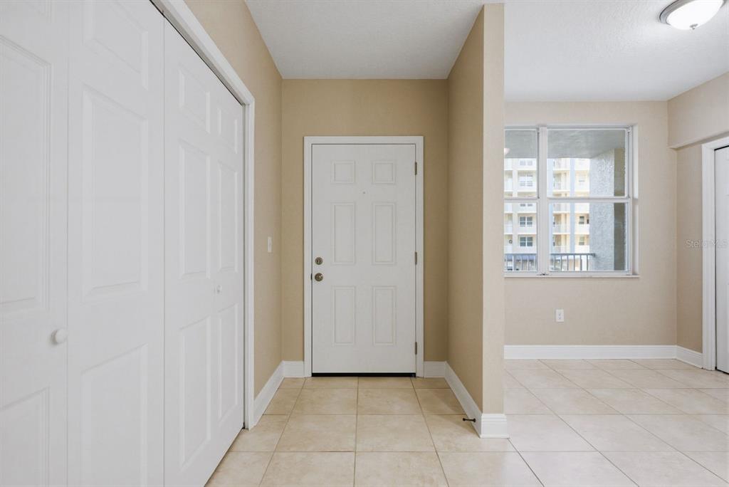 An entryway features beige tile flooring, a white front door, and a white closet door — 960 STARKEY ROAD UNIT 5105, LARGO, FL