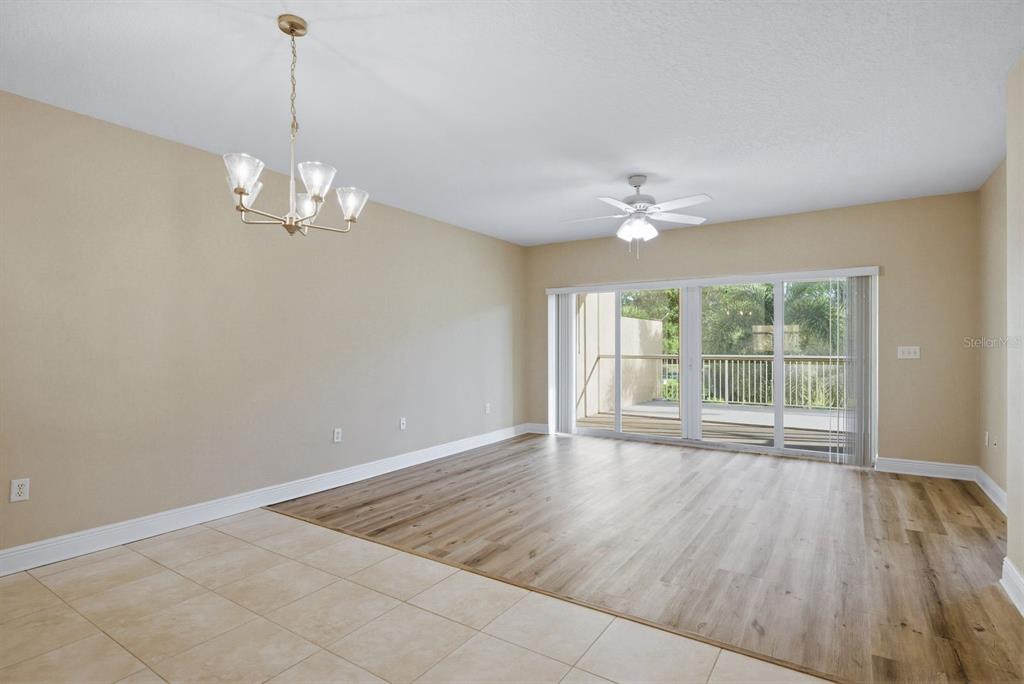 A living area with wood-look flooring, a ceiling fan, and sliding glass doors to a balcony — 960 STARKEY ROAD UNIT 5105, LARGO, FL