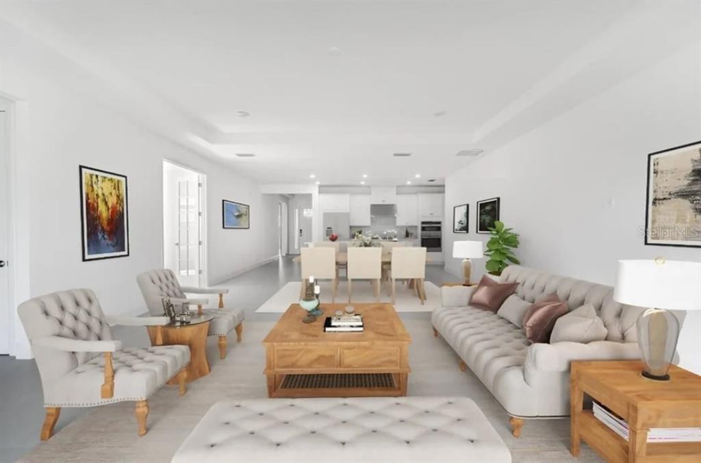 A bright, open-concept living and dining area features neutral furniture, white walls, and tile flooring — 12940 HARVEST RAIN AVENUE, WINTER GARDEN, FL