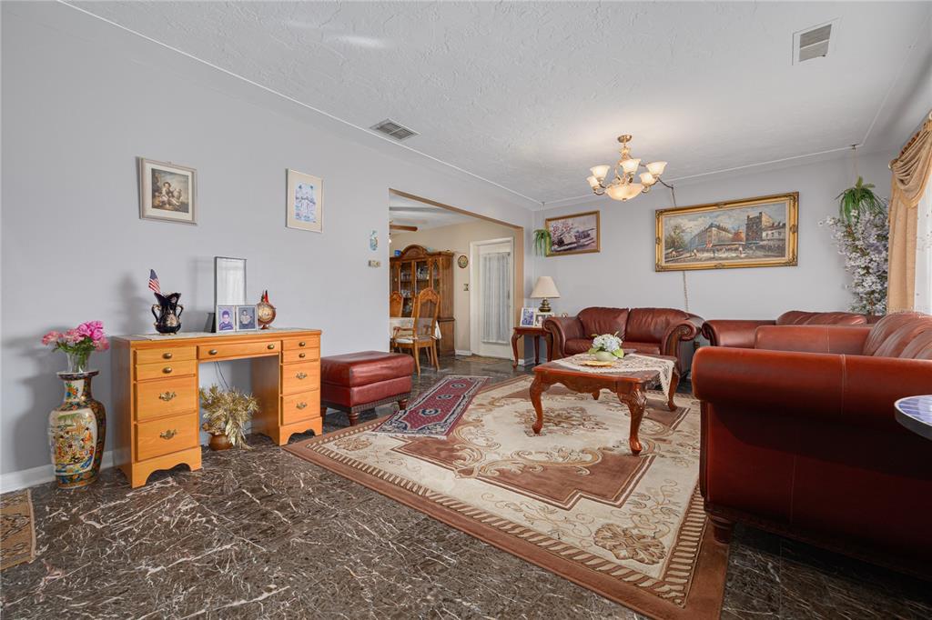 A living room with marble floors, leather furniture, a wooden desk, and a large rug — 1715 S JEFFERSON AVENUE, LARGO, FL