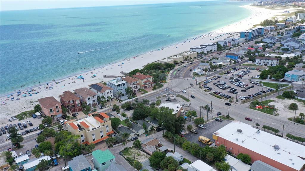 An aerial view shows a beach, coastal buildings, a parking lot, and intersecting roads — 101 95TH AVENUE, TREASURE ISLAND, FL