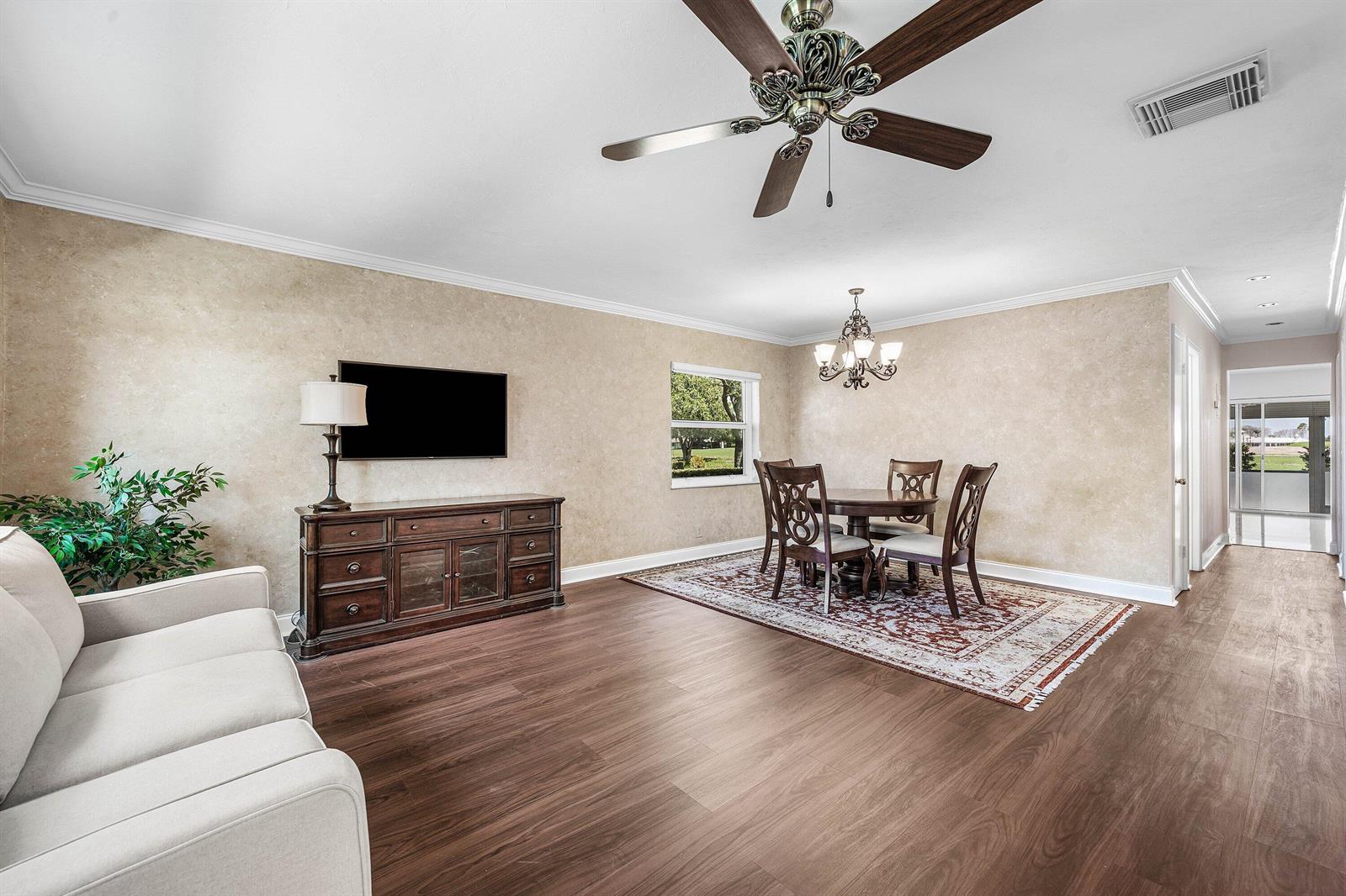 A living and dining area features wood-look flooring, a ceiling fan, and a wall-mounted television — 2303 Lowson Boulevard # D, Delray Beach FL 33445, DELRAY BEACH, FL