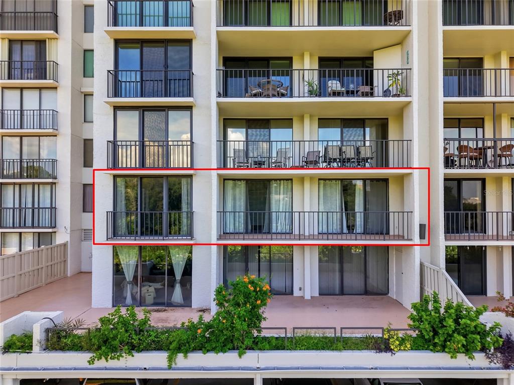 An exterior view of a multi-story apartment building featuring balconies with glass sliding doors — 220 BELLEVIEW BOULEVARD UNIT 207, BELLEAIR, FL