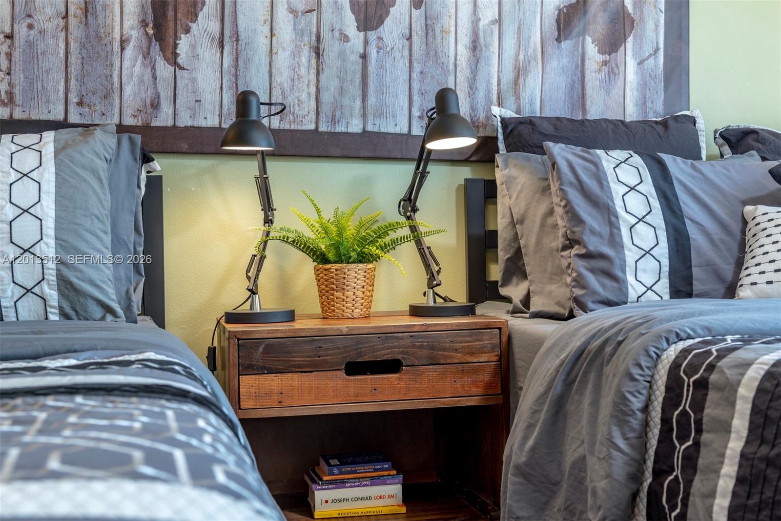 A bedroom features two twin beds separated by a rustic wooden nightstand with two lamps — 200 178th Dr # 604, Sunny Isles Beach FL 33160, SUNNY ISLES BEACH, FL