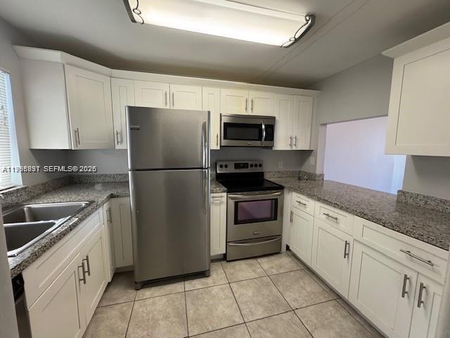 A kitchen features white cabinets, granite countertops, and stainless steel appliances — 9421 Evergreen Pl # 403, Davie FL 33324, DAVIE, FL