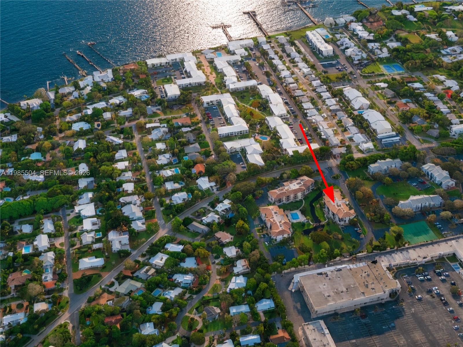 An aerial view shows a residential complex with a red arrow pointing toward a building — 166 SE St Lucie Blvd # Un # 203, Stuart FL 34996, STUART, FL