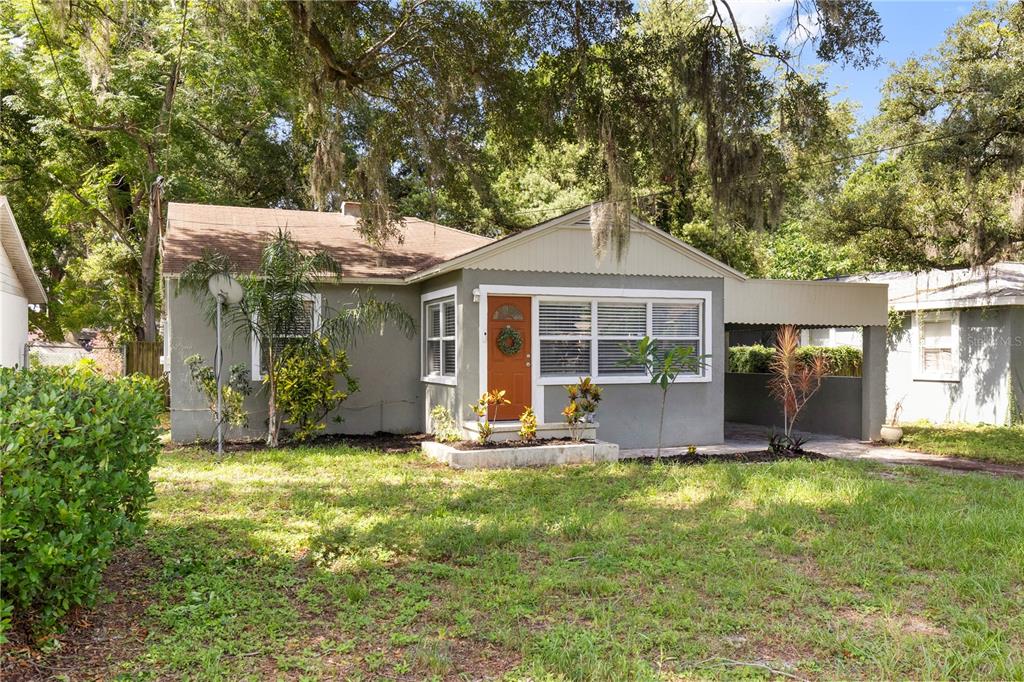 A single-story house with a gray exterior, orange front door, and an attached carport — 2013 E HENRY AVENUE, TAMPA, FL