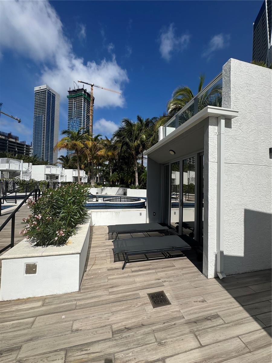 A patio with lounge chairs, wood-look tile flooring, and a view of nearby high-rise buildings — 851 NE 1st ave # 7, Miami FL 33132, MIAMI, FL