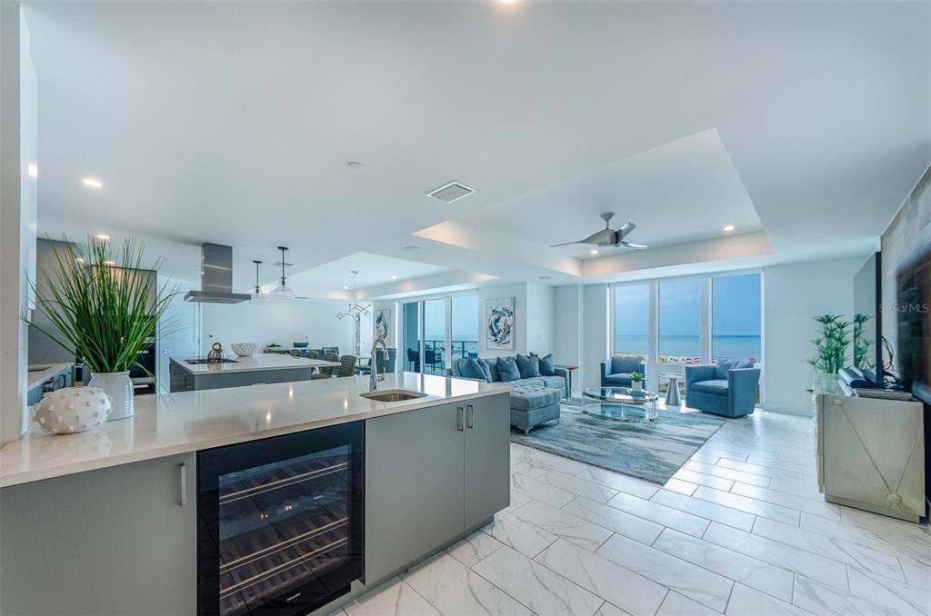 A modern open-concept kitchen and living area features white marble floors and ocean views — 15 AVALON STREET UNIT 401, CLEARWATER BEACH, FL