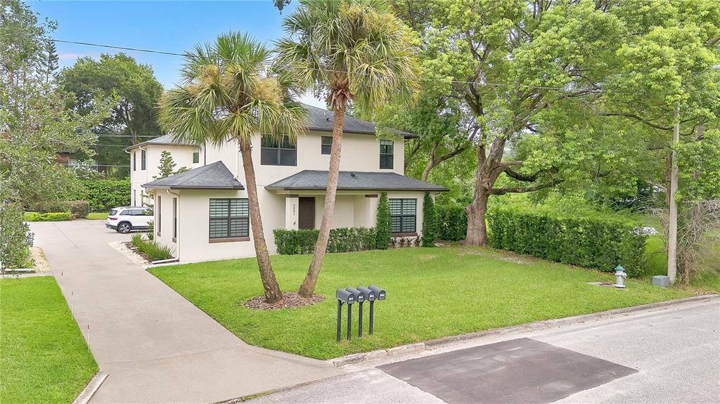 A two-story house with a concrete driveway, palm trees, and a lawn in front — 2251 NAIRN DRIVE, WINTER PARK, FL