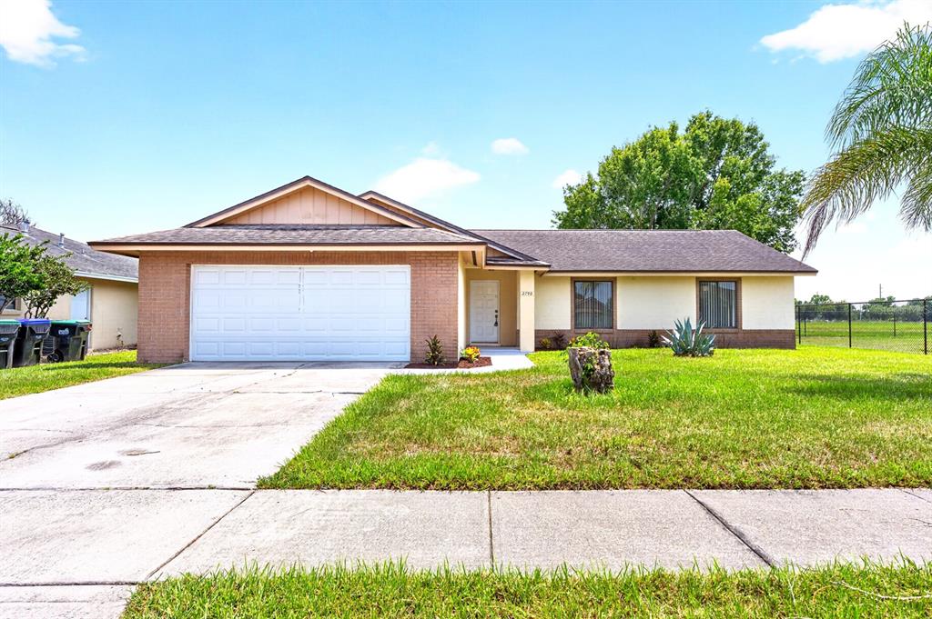 A single-story house with a brick facade, a two-car garage, and a large front lawn — 2790 MUSCATELLO STREET, ORLANDO, FL