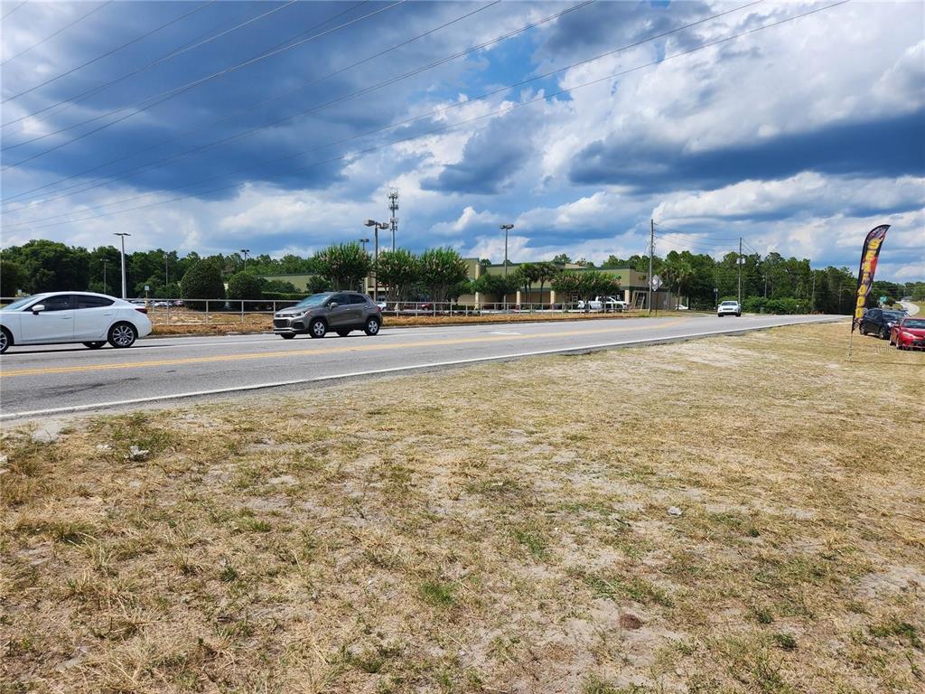 A view of a road with cars passing in front of a commercial building — 7013 SE MARICAMP ROAD, OCALA, FL