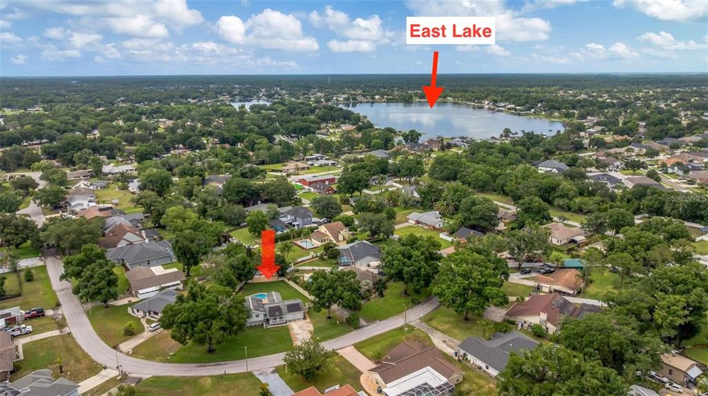 An aerial view shows a residential neighborhood with a house highlighted near a large lake — 22369 SOUTHSHORE DRIVE, LAND O LAKES, FL