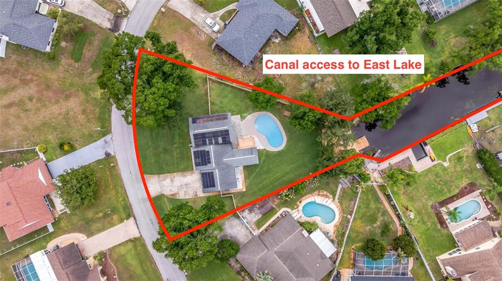 An aerial view shows a house with a swimming pool and canal access — 22369 SOUTHSHORE DRIVE, LAND O LAKES, FL