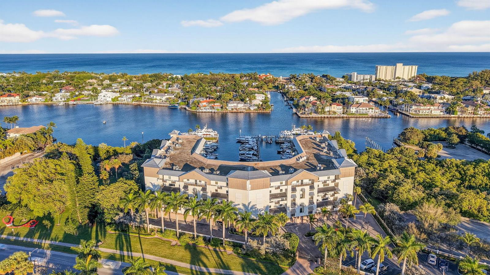 An aerial view shows a U-shaped waterfront apartment building with a private boat marina — 1035 S Federal Highway # 402, Delray Beach FL 33483, DELRAY BEACH, FL