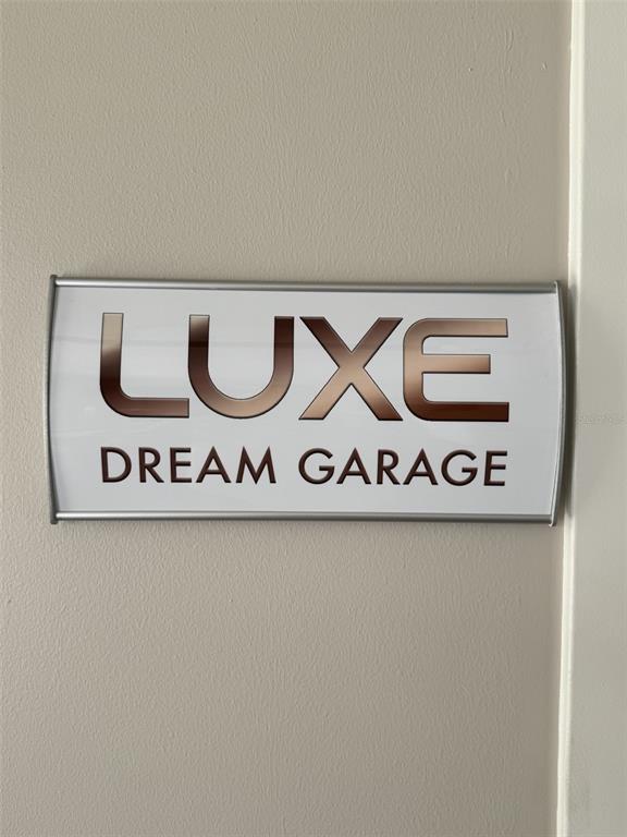 A wall-mounted sign displays the text LUXE DREAM GARAGE in a silver frame — 5431 COMMUNICATIONS PARKWAY UNIT 20, SARASOTA, FL