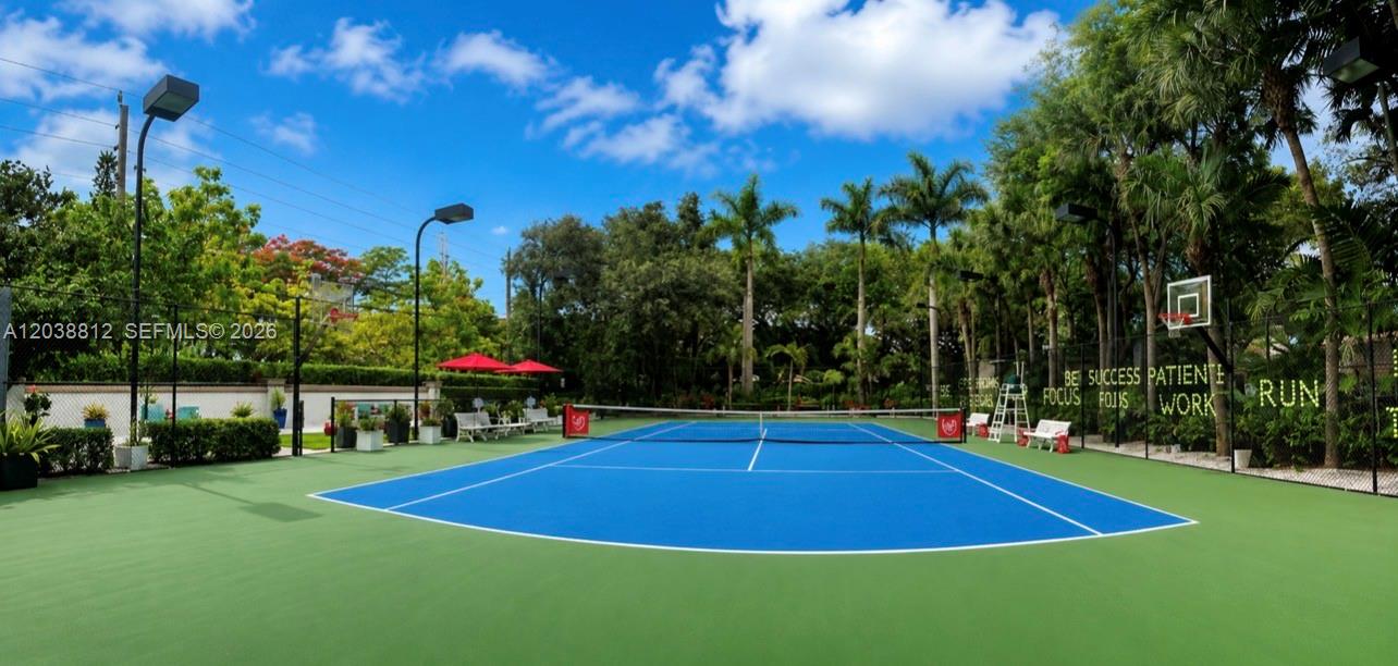 An outdoor tennis court with a blue surface and green perimeter surrounded by trees — 10395 SW 67th Ave, Pinecrest FL 33156, PINECREST, FL