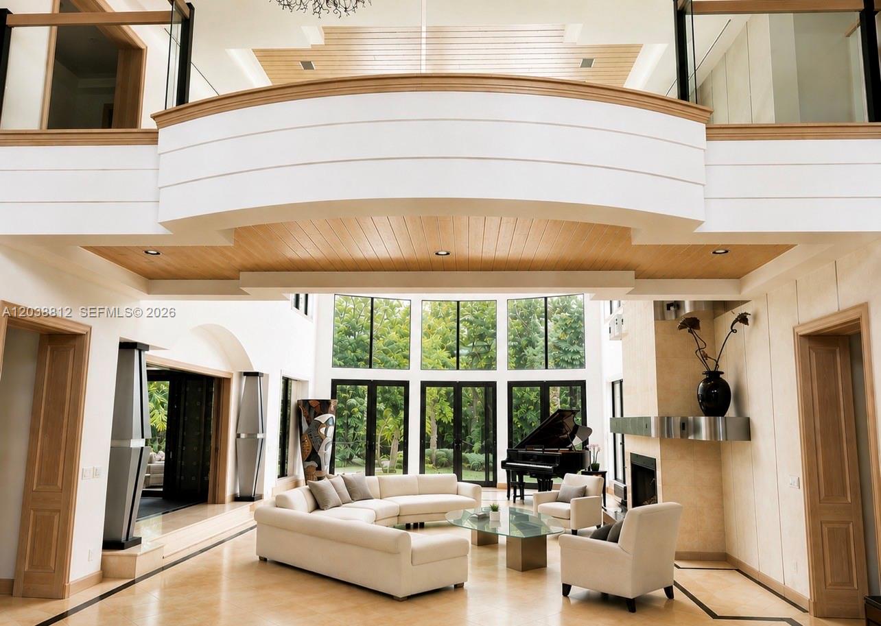 A spacious living room features a grand piano, white sectional sofa, and a fireplace — 10395 SW 67th Ave, Pinecrest FL 33156, PINECREST, FL