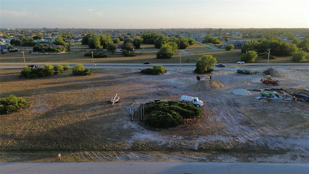 An aerial view shows a cleared, sandy construction lot with a truck and equipment — 1508 NW 16TH TERRACE, CAPE CORAL, FL