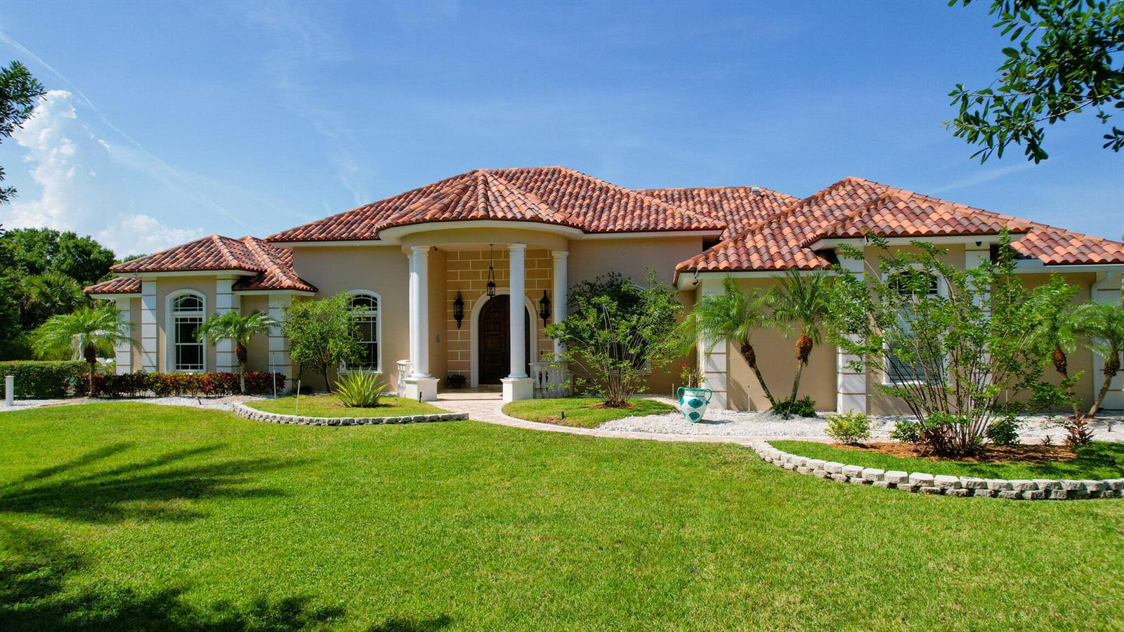 A single-story house with a terracotta tile roof, beige stucco walls, and white columns — 6780 49th Street, Vero Beach FL 32967, VERO BEACH, FL