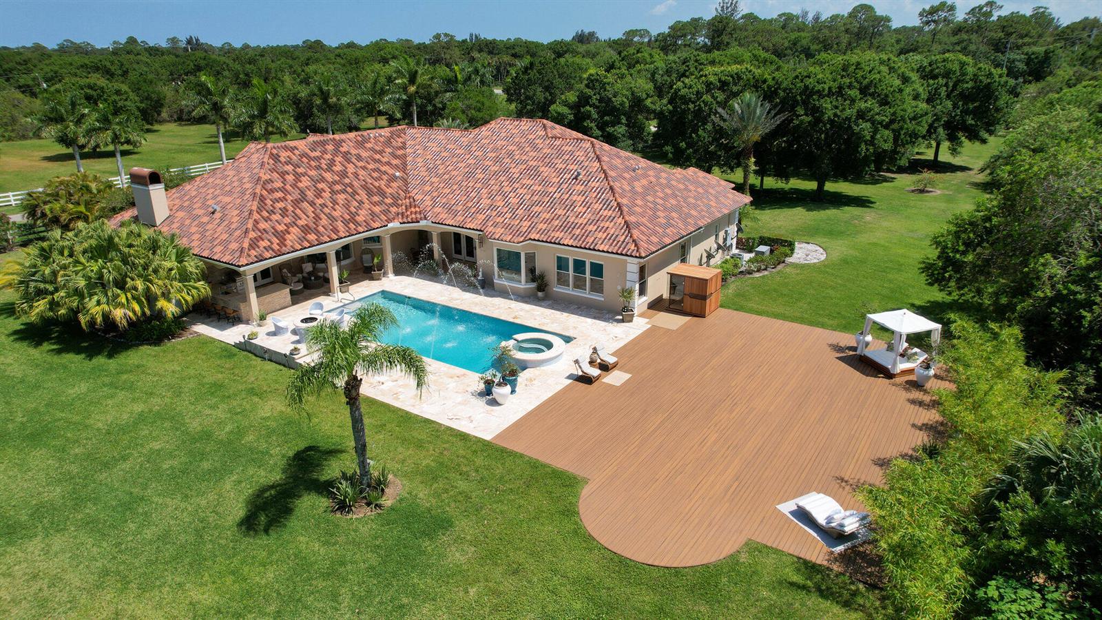 An aerial view of a house with a tiled roof, swimming pool, and wooden deck — 6780 49th Street, Vero Beach FL 32967, VERO BEACH, FL
