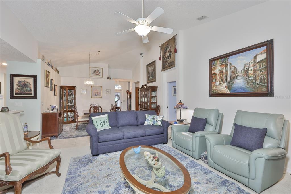 A living room features a blue sofa, two light blue armchairs, and a dining area — 2305 OLIVE BRANCH DRIVE, SUN CITY CENTER, FL