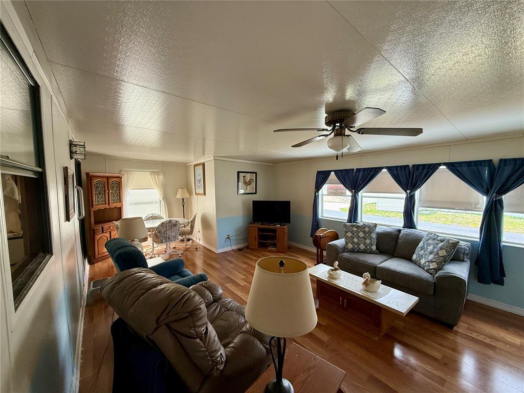 A living room with wood floors, a ceiling fan, and a gray sofa — 7360 INTERNATIONAL CIRCLE, LAKE WALES, FL