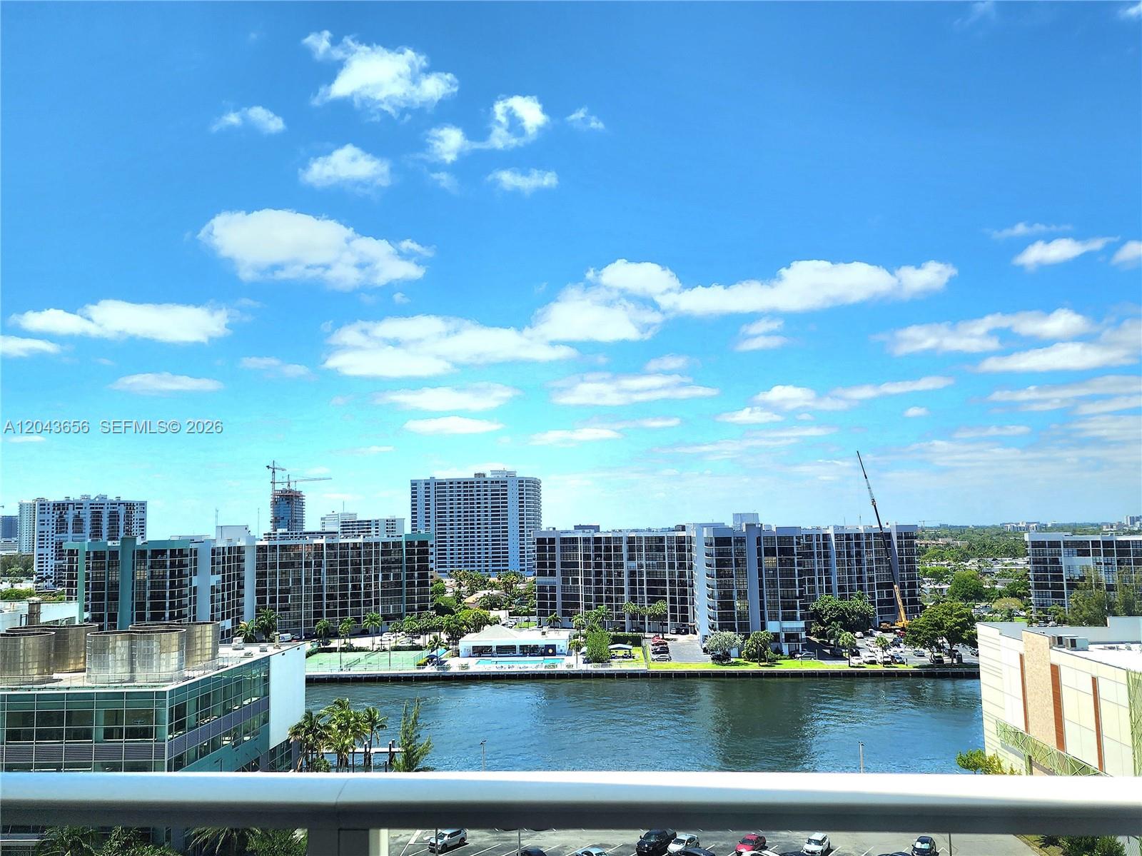 An elevated view shows a waterway, residential buildings, and a construction crane under a blue sky — 3505 S Ocean Dr # 1103, Hollywood FL 33019, HOLLYWOOD, FL