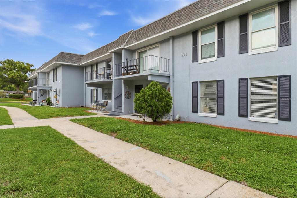 A two-story apartment building with gray stucco walls, dark shutters, and concrete walkways — 931 W OAK RIDGE ROAD UNIT B, ORLANDO, FL