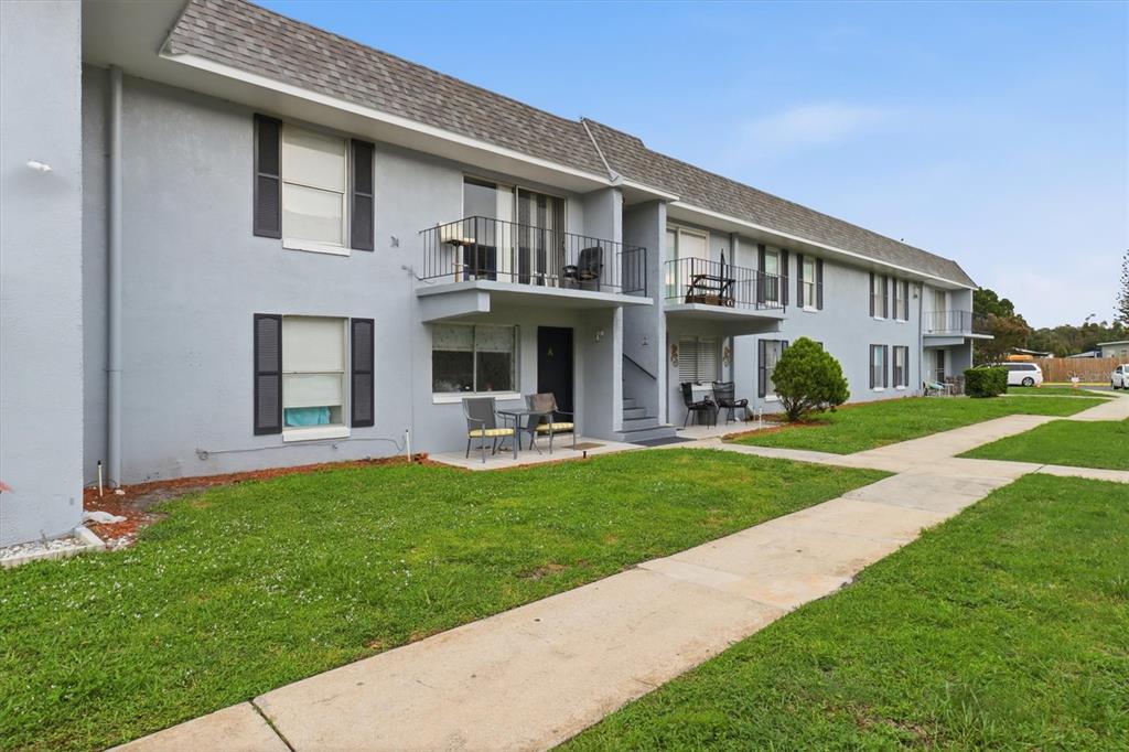A two-story apartment building with gray stucco walls, balconies, and a concrete walkway — 931 W OAK RIDGE ROAD UNIT B, ORLANDO, FL